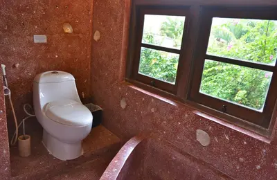 a bathroom with a toilet and a tub and a window at Villa Una in Seminyak