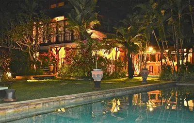a house with a swimming pool at night at Villa Una in Seminyak