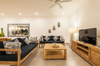 a living room with a couch and a tv at Ambermoon Villas in Seminyak