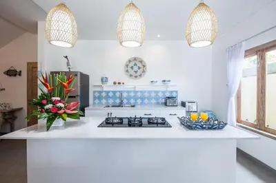 a white kitchen with a stove and a sink at Ambermoon Villas in Seminyak