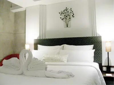 a bedroom with two swans towels on a bed at Anshel Hotel Seminyak in Seminyak