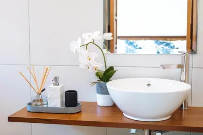 a bathroom with a white sink and flowers on a wooden counter at Villa Alliv in Seminyak