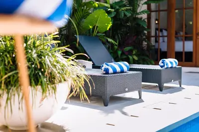a patio with two lounge chairs with blue and white pillows at Villa Alliv in Seminyak