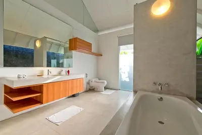 a bathroom with a tub and a sink and a toilet at White Villa in Seminyak