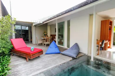 a house with a deck and a swimming pool at White Villa in Seminyak