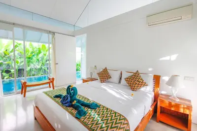 a bedroom with a bed with a teddy bear on it at White Villa in Seminyak