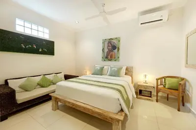a bedroom with a large bed and a couch at Villa Alba in Seminyak