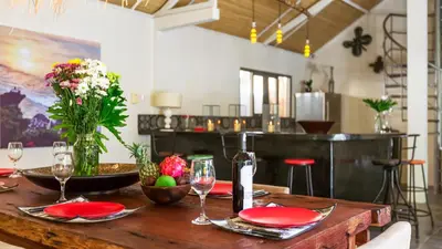 a wooden table with red plates and wine glasses at Luxury Villa Kudeta 300m BEACH and heart of Seminyak in Seminyak