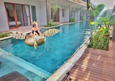 a woman sitting in an inflatable raft in a swimming pool at Mahana Living in Denpasar