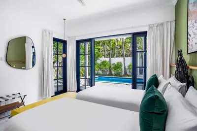 a bedroom with a large bed and a large window at The Beach House in Canggu