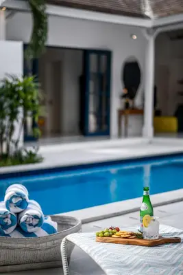 a tray of food sitting on a table next to a pool at The Beach House in Canggu