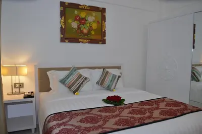 a bedroom with a bed with a flower on it at Sofi Apartment at Jayakarta Residence in Legian