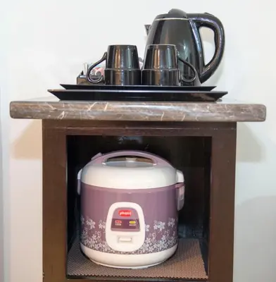 a slow cooker in a shelf with two tea pots at Sofi Apartment at Jayakarta Residence in Legian
