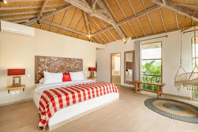 a bedroom with a bed with a red and white blanket at Villa Dipta in Seminyak