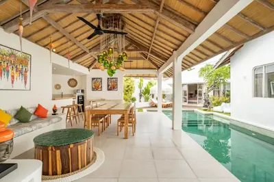 an open living room and dining room with a swimming pool at Villa Dipta in Seminyak