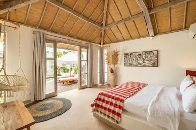 a bedroom with a bed in a room with a patio at Villa Dipta in Seminyak
