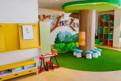 a childrens play room with a tree and a table at Tijili Hotel Benoa in Nusa Dua