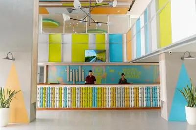 a lobby with two people standing at a counter at Tijili Hotel Benoa in Nusa Dua