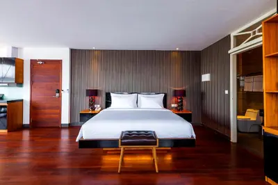 a bedroom with a large bed and a bathroom at Imani Suites in Seminyak
