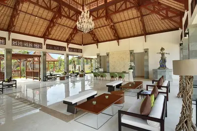 a lobby with chairs and tables and a chandelier at Royal Tulip Springhill Resort Jimbaran in Jimbaran