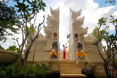 a woman standing in front of a white building at Royal Tulip Springhill Resort Jimbaran in Jimbaran