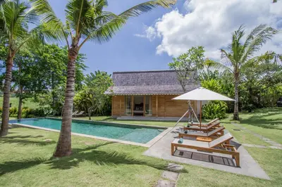 a villa with a swimming pool and a resort at Alea Estate in Kerobokan