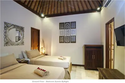 a bedroom with two beds and a mirror and a tv at 2BR Villa Senin - Minggu Villas Seminyak in Seminyak