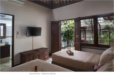 a bedroom with two beds and a flat screen tv at 2BR Villa Senin - Minggu Villas Seminyak in Seminyak