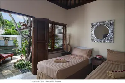 a bedroom with two beds and a mirror on the wall at 2BR Villa Senin - Minggu Villas Seminyak in Seminyak