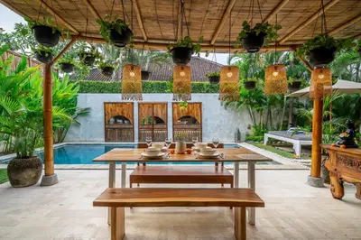 a table and benches in a patio with a pool at Villa Sarong 2 Chic 2BR Boho Villa Prime Central Location in Seminyak