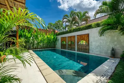 a swimming pool in the backyard of a house with palm trees at Villa Sarong 2 Chic 2BR Boho Villa Prime Central Location in Seminyak