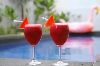 three cocktails in glasses with water melons in them at Kubu GWK Villa in Jimbaran