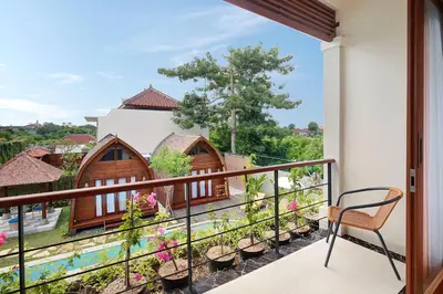 a balcony with a view of a house at Kubu GWK Villa in Jimbaran