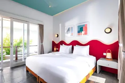 a bedroom with a large white bed with a red headboard at Villa Ungava in Seminyak