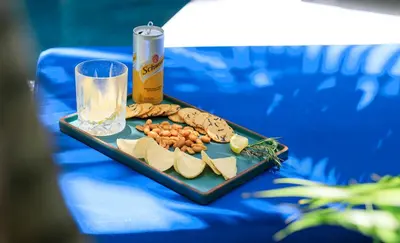 a plate of food on a table with a drink and snacks at Villa Ungava in Seminyak