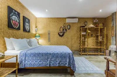 a bedroom with a bed with a blue bedspread at Villa Kundalini in Seminyak