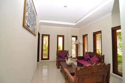 a living room with chairs and a table with purple pillows at Kandava Villa in Jimbaran