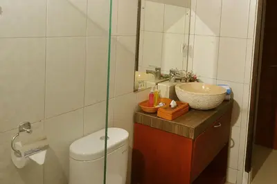 a bathroom with a toilet and a sink and a mirror at Kandava Villa in Jimbaran