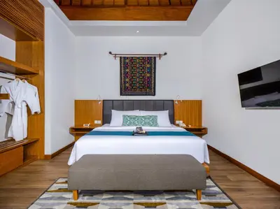 a bedroom with a large bed and a tv at S18 Bali Villas in Legian