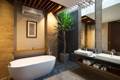 a bathroom with a large tub and two sinks and a potted plant at S18 Bali Villas in Legian