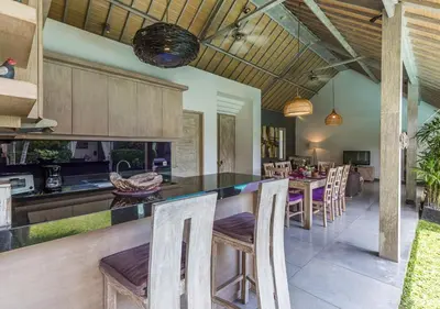 an open kitchen and dining room with a table and chairs at VILLA Nuri Merah 1 in Kerobokan