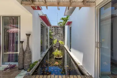 a balcony with a koi pond in the middle of a building at Villa Purple in Legian