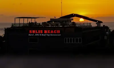 a boat sitting on the beach at sunset at Sulis Beach Hotel & Spa in Kuta
