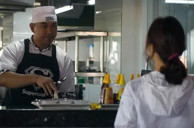 a man and a woman in a kitchen preparing food at Sulis Beach Hotel & Spa in Kuta