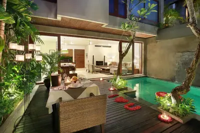 a living room with a pool and a table and a house at Kanishka Villas in Seminyak