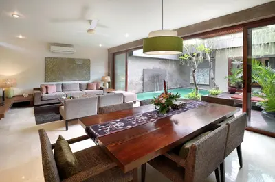 a living room with a wooden table and chairs at Kanishka Villas in Seminyak
