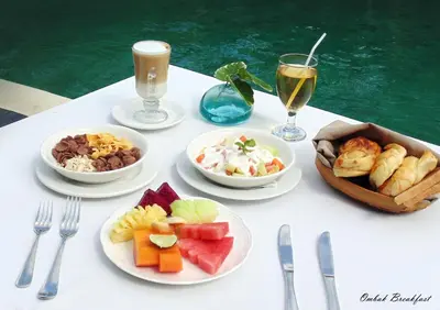 a table with plates of food and glasses of wine at Kanishka Villas in Seminyak