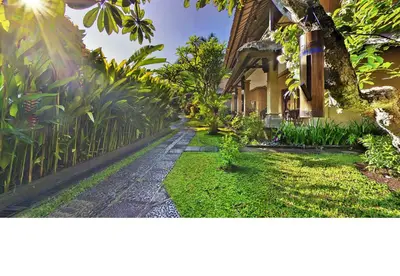 a house with a walkway in front of a yard at Bali Agung Village in Seminyak