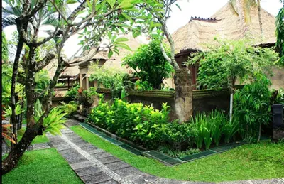 a garden in front of a house with trees and plants at Bali Agung Village in Seminyak