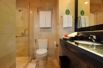 a bathroom with a toilet and a shower and a sink at Best Western Resort Kuta in Kuta